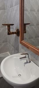 a bathroom with a white sink and a mirror at TheChef NungwiBungalow in Kidoti +42 photos