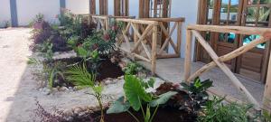 a garden with a wooden bridge and some plants at TheChef NungwiBungalow in Kidoti