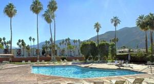 Marquis Villas Resort في بالم سبرينغز: مسبح فيه نخيل وجبال في الخلف