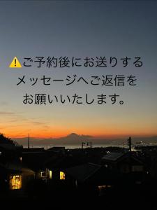uma escrita asiática no céu ao pôr do sol em 葉山ワンルーム古民家ペット可 bbqグリル&ピザ窯付 em Hayama