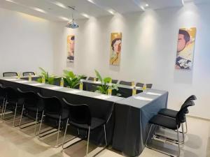 Magnotel Business Xuzhou Jinying Sudi Road Metro Station في سوزهو: طاولة طويلة في غرفة مع كراسي سوداء