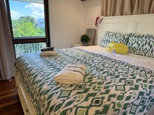 een slaapkamer met een groot bed met handdoeken erop bij 4BR big family house with huge pool in Brisbane +86 foto's