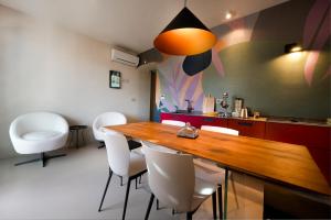 a kitchen with a wooden table and white chairs at Nichis Apartment Relais in Benevento +23 photos