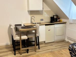 a kitchen with a table and chairs and a sink at Super appartement in Malesherbes +22 photos