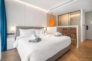 a bedroom with a white bed with two towels on it at Premier Pool View Studio 348 KoraResort in Layan Beach +19 photos