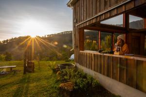une femme est assise sur le rebord d'une fenêtre d'un bâtiment dans l'établissement ไร่ชาดอยอินทนนท์, à Ban Yang Khun Wang