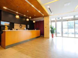 an office lobby with a reception desk and windows at Jinjiang Metropolo Hotel - Taizhou Wanda Plaza in Taizhou