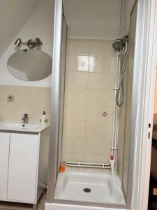 a bathroom with a shower with a tub and a sink at Super appartement in Malesherbes