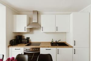 a kitchen with white cabinets and a sink at Harzchalet Brockenbahn 2A in Elend +15 photos