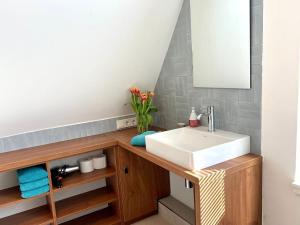 ein Badezimmer mit Waschbecken und Spiegel in der Unterkunft Hus an de Waterkant in Juist + 8 Fotos