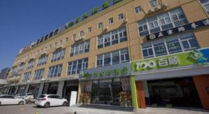 Un gran edificio con coches aparcados delante. en Vatica Beijing Tongzhou Liyuan Universal Studios, en Liyuanzhen