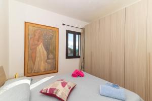 um quarto com uma cama com um quadro na parede em Pupureddu con Terrazza ad Olbia em Olbia