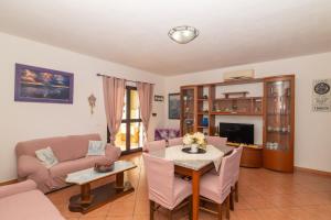 uma sala de estar com uma mesa e um sofá em Pupureddu con Terrazza ad Olbia em Olbia