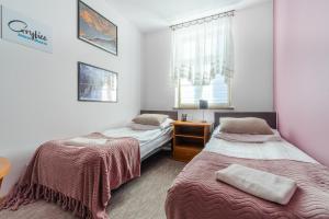 Un dormitorio con dos camas y una ventana. en Dom Pracy Twórczej, en Gryfice