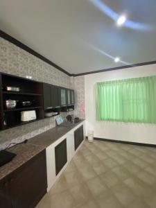 eine große Küche mit einem grünen Fenster in einem Zimmer in der Unterkunft Baan Rungrojn HuaHin in Hua Hin