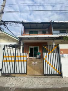 ein Haus mit einem Tor davor in der Unterkunft Baan Rungrojn HuaHin in Hua Hin