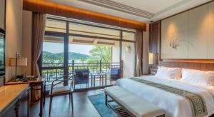 a bedroom with a large bed and a balcony at Pingtian Bandao Hotel in Pai-sha-p'u