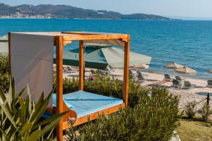a bed on a beach next to the water at Talizeti Home - Adults Only in Sarti