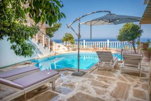una piscina con dos sillas y una sombrilla en Elia, en Kavoúsion