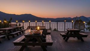 een terras met picknicktafels en uitzicht op het water bij Geoje Badageurigo Pension in Geoje 