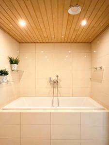 eine Badewanne im Bad mit Holzdecke in der Unterkunft Guest House Salo-City in Salo
