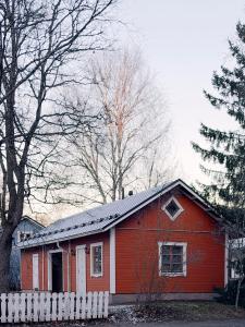 ein rotes Haus mit einem weißen Zaun davor in der Unterkunft Guest House Salo-City in Salo
