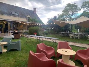 un grupo de sillas y mesas frente a una casa en les hébergements de la ferme des buttons, en Rosnay