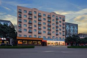 a large pink building in front of a building at Zhangye Pinmu Hotel(Yuncheng Zhongyin Avenue Store) in Yuncheng