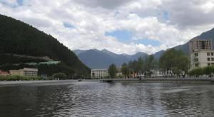 a large body of water with buildings and mountains at GreenTree Inn Tibet Nyingchi City Biji Shenshan in Dagzê