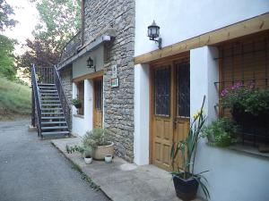 a brick building with a wooden door and a staircase at Casa la Cuadreta in Calvera