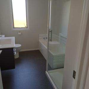 a bathroom with a shower and a sink and a toilet at Modern & Comfort in Central Alexandra in Alexandra