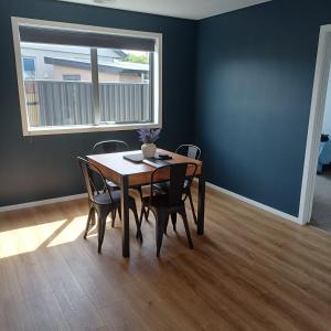 ein Esstisch mit Stühlen und ein Fenster in der Unterkunft Modern & Comfort in Central Alexandra in Alexandra + 6 Fotos