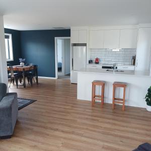 a kitchen and living room with a table and chairs at Modern & Comfort in Central Alexandra in Alexandra