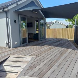 a porch with a wooden deck in front of a house at Modern & Comfort in Central Alexandra in Alexandra