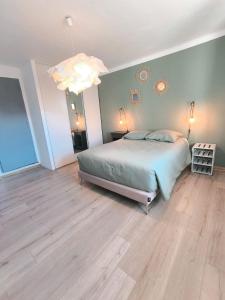 a bedroom with a bed and a chandelier at La Maison de la Baume in Volonne