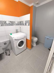 a bathroom with a washing machine and a toilet at La Maison de la Baume in Volonne