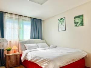 Un dormitorio con una cama blanca y una ventana. en 루미스테이, en Ulsan 49 fotos más