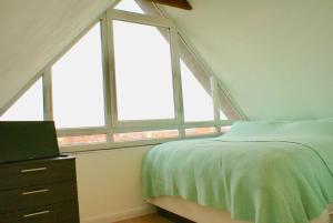 于斯德Strandhaus Rose的一间卧室设有2个窗户和1张床,配有电视