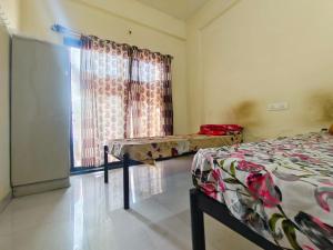 duas camas em um quarto com janela em Shree Sairam Pg em Pune