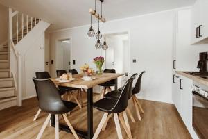 a dining room with a wooden table and black chairs at Harzchalet Brockenbahn 2B in Elend +19 photos