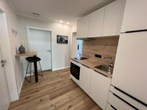 Eine Küche mit weißen Schränken und Holzboden in der Unterkunft Dünen Lodge 2 in Juist