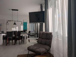 un soggiorno con sedia e TV a parete di Strandhaus Rose a Juist