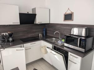 una cucina con forno a microonde e lavandino di Strandhaus Rose a Juist Altre 18 foto