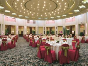 a large banquet hall with white tables and red chairs at Dongguan MCB Lake Hotel in Dongguan +211 photos