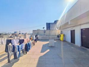 uma fileira de roupas penduradas em um varal na parede de um prédio em Shree Sairam Pg em Pune