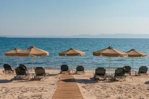 a group of chairs and umbrellas on a beach at Talizeti Home - Adults Only in Sarti