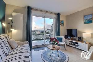 a living room with a couch and a tv at Le balcon de la baie in Paimpol