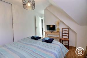 a bedroom with a bed with two blue pillows on it at Le balcon de la baie in Paimpol