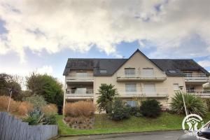 a white house with a black roof at Le balcon de la baie in Paimpol