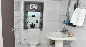 a bathroom with a toilet and a sink and a clock at Grand Dhaka Hotel in Dhaka +68 photos